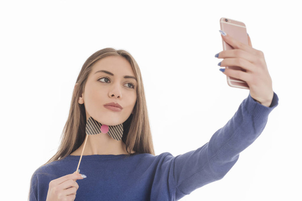 Beautiful girl taking selfie with paper bow tie - Foto, afbeelding