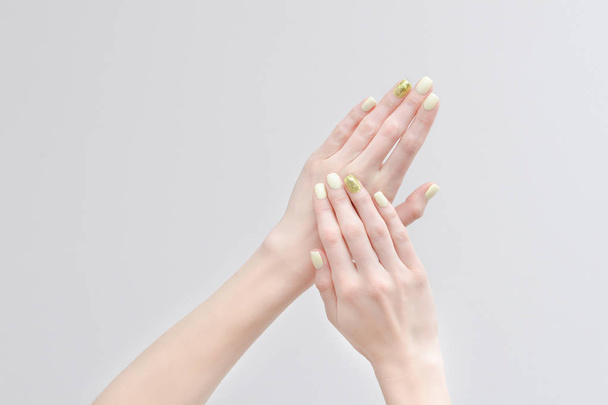 Όμορφα Γυναικεία χέρια με ένα μανικιούρ σε ανοιχτόχρωμο φόντο - Φωτογραφία, εικόνα