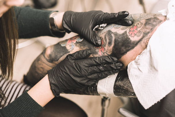 tattoo artist makes a pedicure to the client - Photo, Image