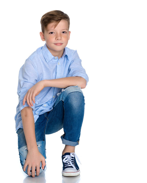Fashionable boy teen sitting on the floor. - Foto, afbeelding