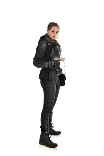 full length portrait of female  soldier wearing black  tactical armour, holding a gun, isolated on white studio background. - Photo, Image
