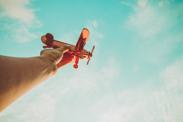 Игрушечный самолет в руке - вдохновение для путешествий и мечтаний. Эффект винтажного цветового фильтра
. - Фото, изображение