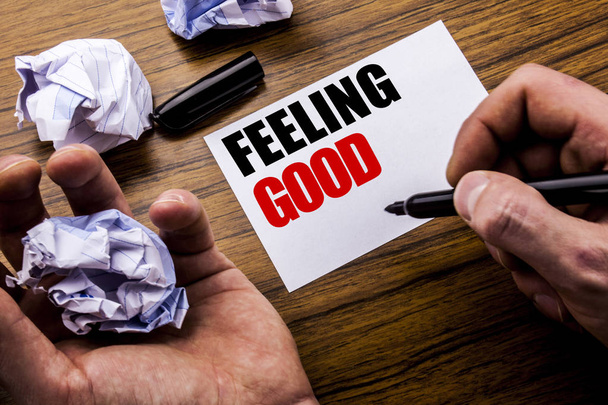 Handwriting text   Feeling Good. Concept for Happy Positive Attitude written on notebook note paper on the wooden background with folded paper meaning thinking for idea. Man hand and marker. - Photo, Image