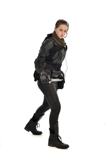 portrait complet d'une femme soldat portant une armure tactique noire, tenant un couteau, isolée sur fond de studio blanc
. - Photo, image