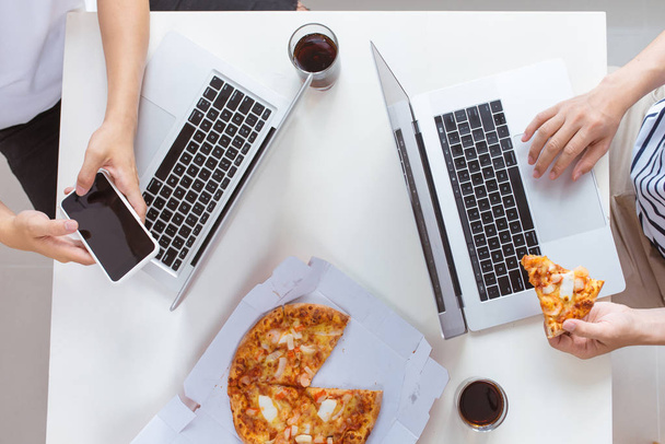 ファーストフードを食べます。オフィスでピザを食べて幸せなビジネス チーム - 写真・画像