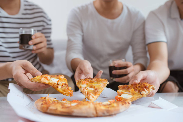 Люди едят фаст-фуд. Друзья берут кусочки пиццы
 - Фото, изображение