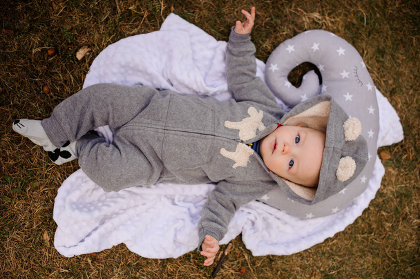 Cute baby dressed in romper with hood lying on the pillow - Foto, Imagem
