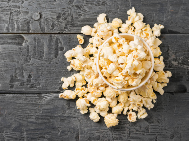 Popcorn in a paper Cup and on the table. The view from the top. - Foto, Imagen