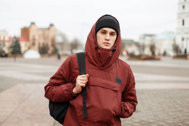 Beautiful fashionable man in a red stylish jacket with a hood wi - Fotoğraf, Görsel
