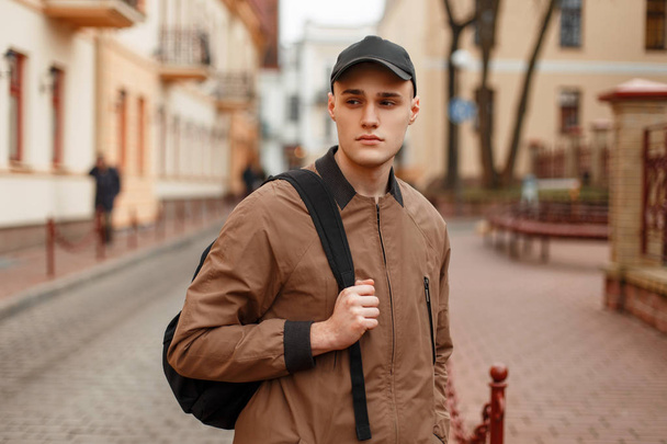 стильный молодой человек в винтажном пальто в кепке
 - Фото, изображение
