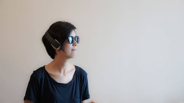 Cool Asian woman hipster lifestyle using headphones and wearing  - Photo, Image