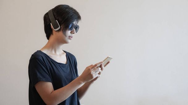 Asian woman lifestyle using smartphone while using headphones an - Foto, afbeelding