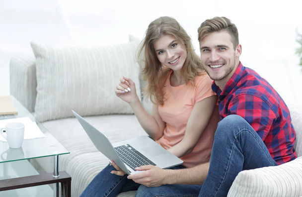 pair students with a laptop sitting on sofa - Photo, image
