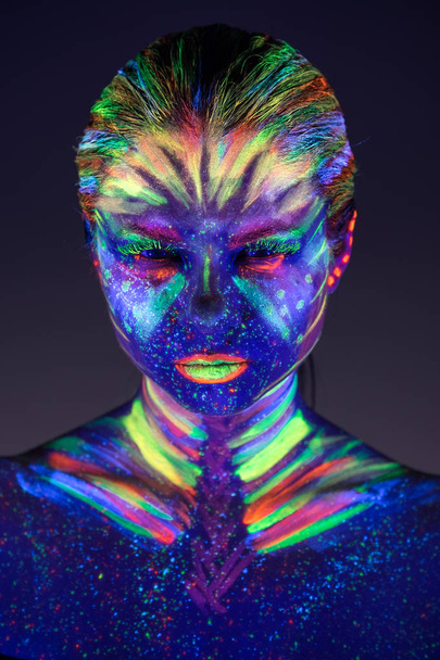 Portrait of beautiful girl with ultraviolet paint on her face. G - Φωτογραφία, εικόνα