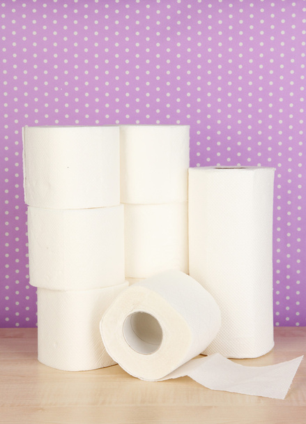 Rolls of toilet paper on purple with dots background - 写真・画像