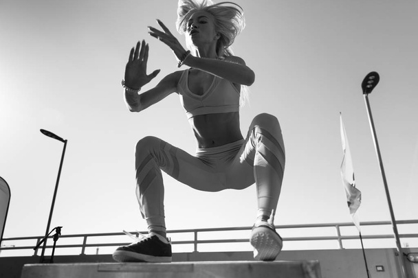 Fit young woman doing box jumping. - Фото, изображение
