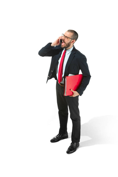 Homme d'affaires heureux parlant au téléphone avec dossier à la main isolé sur fond blanc dans le studio
 - Photo, image