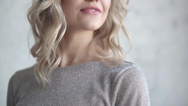 close-up portrait of an attractive blonde. young girl with a light make-up and curls - Footage, Video