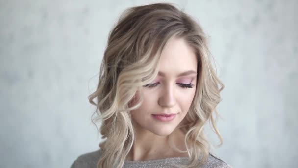 Detailní portrét atraktivní blondýna. mladá dívka s lehký make-up a lokny - Záběry, video