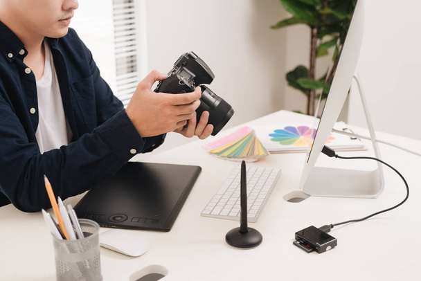 Photographer working at desk in modern office - Photo, Image