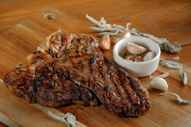 viande grillée à l'ail et aux épices sur planche de bois sur fond de table
    - Photo, image