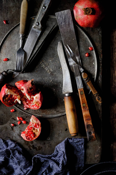 close-up of fresh pomegranate berries with blue scarf and vintage kitchen utensils on  background  - Foto, imagen