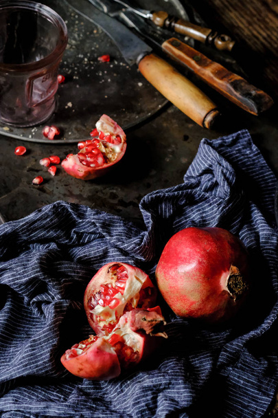 close-up of fresh pomegranate berries with blue scarf on vintage background  - Foto, imagen