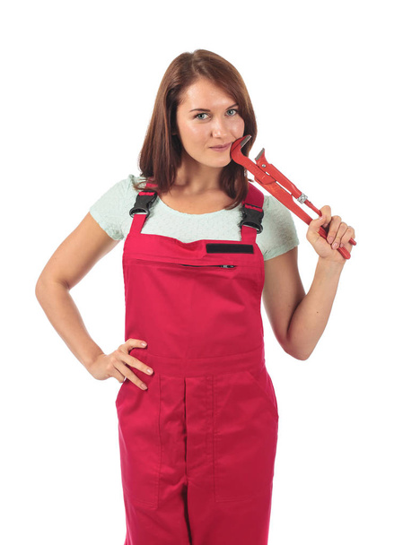 Молода жінка в червоному комбінезоні з гайковим ключем в руці, ізольована на
 - Фото, зображення