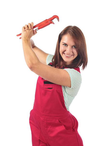 Young woman in red jumpsuit with wrench in hand, isolated on whi - Fotó, kép