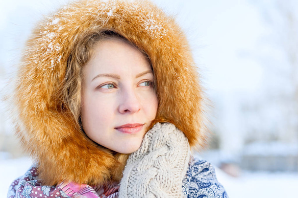 Outdoor portrait young girl in a fur hood - Foto, afbeelding