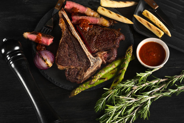 Grillezett húsok és zöldségek, fűszerek és a rozmaring, a háttér fekete lemez    - Fotó, kép