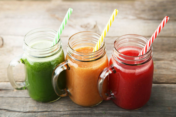 Sweet smoothie in glass jars on grey wooden table - Foto, Imagen