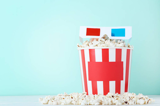 Popcorn in striped bucket with glasses on mint background - Zdjęcie, obraz