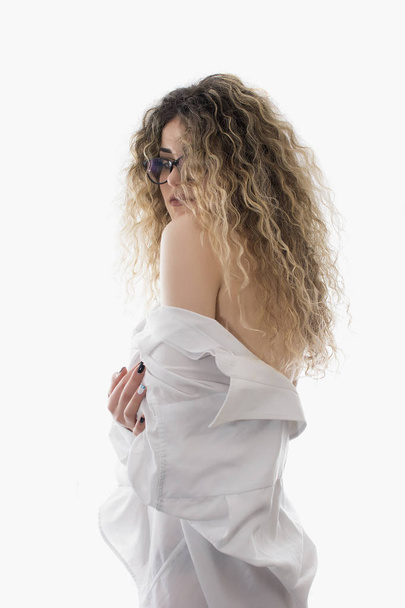 Woman with curly hair and white shirt posing on white background - Fotó, kép