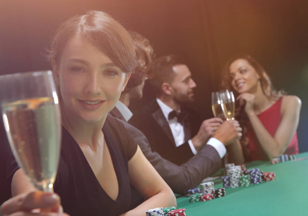 portrait of smiling woman with drink playing poker - Photo, Image