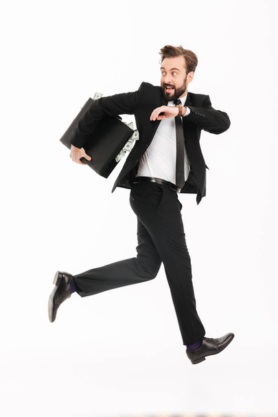 Excited young businessman with suitcase running - Foto, afbeelding
