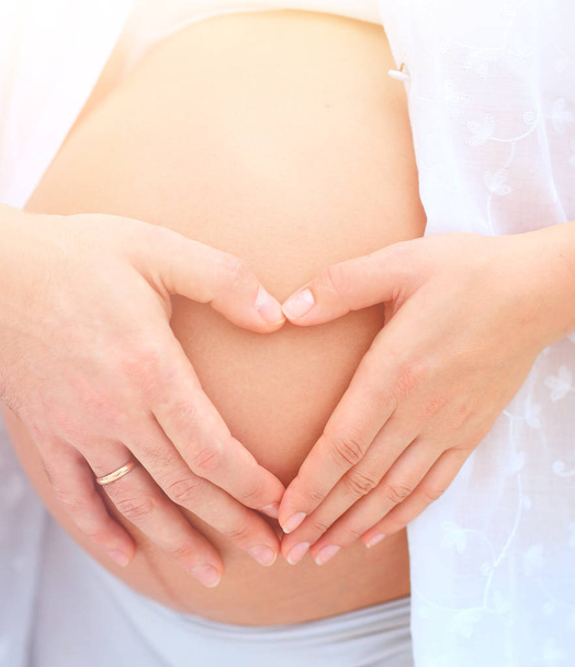 mari et femme enceinte avec les mains pliées en forme de coeur sur son ventre
 - Photo, image