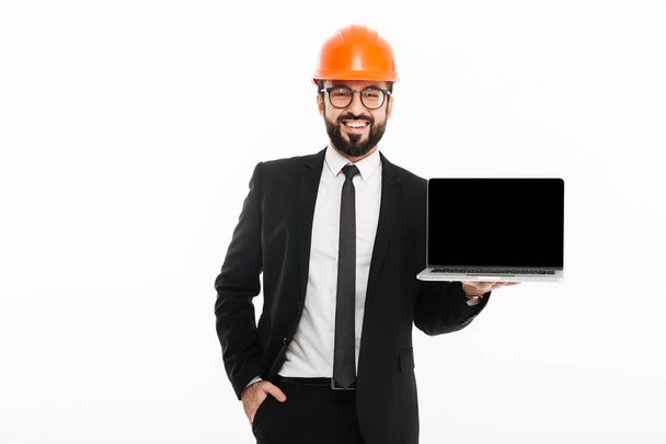 Alegre constructor ingeniero con casco que muestra la pantalla de la computadora portátil
 - Foto, imagen