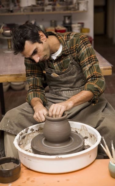 Vista de detalle de cerca en un artista hace cerámica de arcilla en una rueda giratoria
 - Foto, imagen