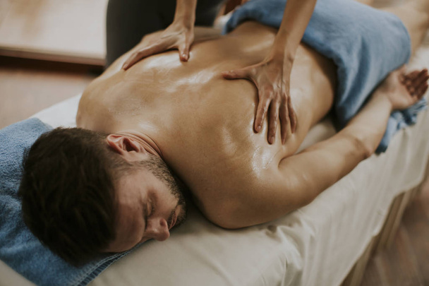Jeune homme ayant massage relaxant dans le spa
 - Photo, image