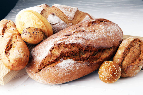 έννοια αρτοποιείο με ψωμί και το ψωμί που κυλά σε λευκό φόντο - Φωτογραφία, εικόνα