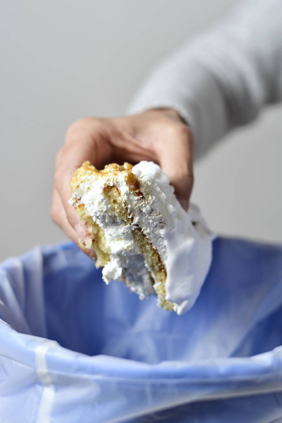 man throwing a piece of cake to the trash bin - Photo, Image