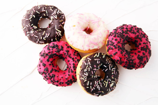 geassorteerde donuts met chocolade frosted, roze geglazuurd en bestrooi - Foto, afbeelding