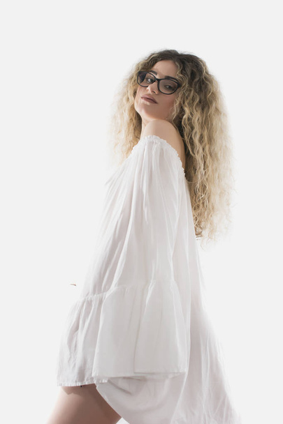 Woman with curly hair and white dress posing on white background - Photo, Image