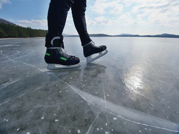 Adam buz donmuş gölde buz pateni. İnce buz adam aşağıda deeep çatlaklar ile - Fotoğraf, Görsel