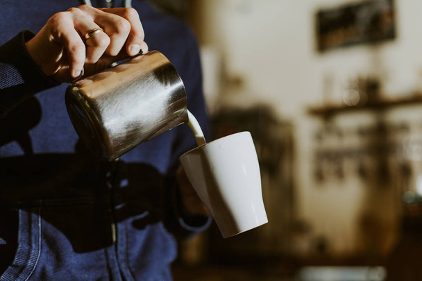 Barista lait fumant dans le pichet avec machine à café se préparant à faire latte art dans le café
 - Photo, image