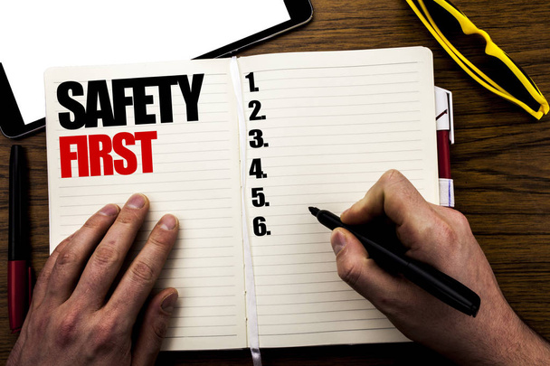 Slovo, psaní Safety First. Obchodní koncept pro bezpečné varování napsal o knize, dřevěné pozadí podnikatel rukou, prstem, psaní na notebooku. - Fotografie, Obrázek