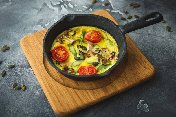 Healthy vegetarian omelet in frying pan and pumpkin seeds. - Zdjęcie, obraz