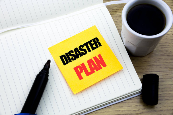 Hand writing text caption inspiration showing Disaster Plan. Business concept for Emergency Recovery written on sticky note paper, Wooden background with space, Coffee and marker - Photo, Image