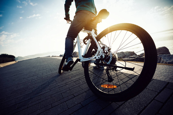 cyclist riding bike in seaside path during sunrise - Zdjęcie, obraz